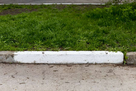 Whitewashed or painted white curb. Background in urban environment with copy spaceの写真素材