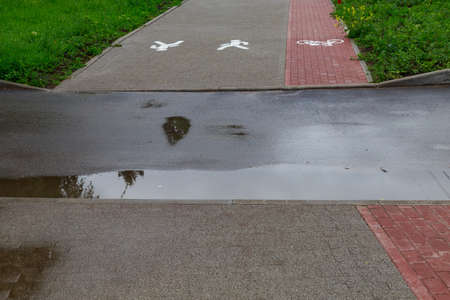 Puddles in an urban environment. Background with copy space for text or inscriptions.の写真素材