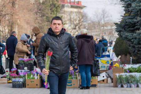 Men buy flowers on the eve of International Women's Day. March 7, 2021 Balti Moldova. Illustrative editorialのeditorial素材