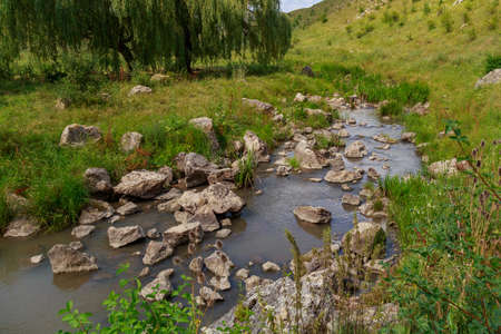 Mountain river or stream with stones in the canyon valley. Nature background with copy space for text or lettering.の写真素材