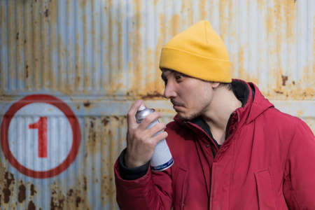 The man sniffs what the spray paint smells like. Selective focus backgroundの写真素材