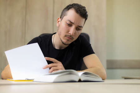 Young male student in the learning process with a pen and abstract.