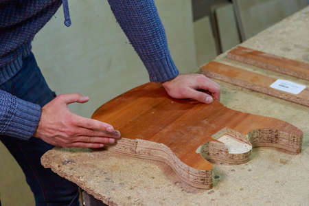 Manufacture of homemade guitar from chipboard. Background with selective focus and copy space for text or lettering. Form grinding.の写真素材