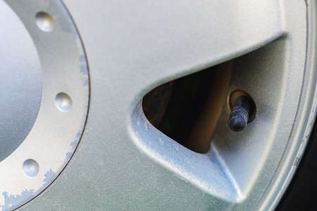 Nipple cap on the wheel. Place the air replenishment tires. Toned background with selective focus and copy space for text or lettering.の写真素材