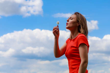 Young pretty woman in colored dress on lightning cheerful yellow background of blooming rapeseed field. Inspiration conceptの写真素材