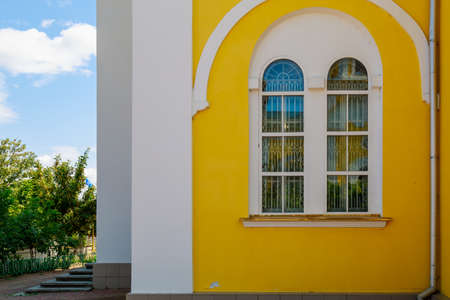 A beautiful yellow church in central park. Welcome to Gagauzia, Moldova. Comrat city center. Background with copy space for text or letteringの写真素材