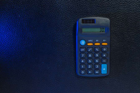 Classic typical black calculator. Economy and accounting symbol. Mathematics and accurate calculations. Maintaining a family budget. Background with copy space for text or letteringの写真素材