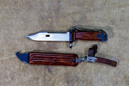 Bayonet knife from AK-47 Kalashnikov assault rifle. Combat knife on wooden background. Army military symbol.の写真素材