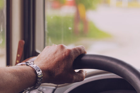 The hands of a professional driver on the steering wheel. Background with copy space for text. Tonedの写真素材