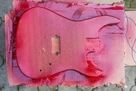 Manufacture of homemade guitar from chipboard. Background with selective focus and copy space for text or lettering. Painting the product.の写真素材