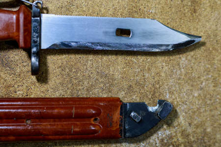 Bayonet knife from AK-47 Kalashnikov assault rifle. Combat knife on wooden background. Army military symbol.の写真素材
