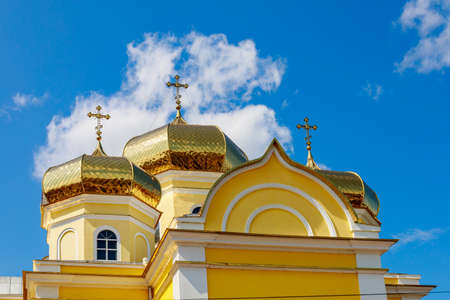 A beautiful yellow church in central park. Welcome to Gagauzia, Moldova. Comrat city center. Background with copy space for text or letteringの写真素材