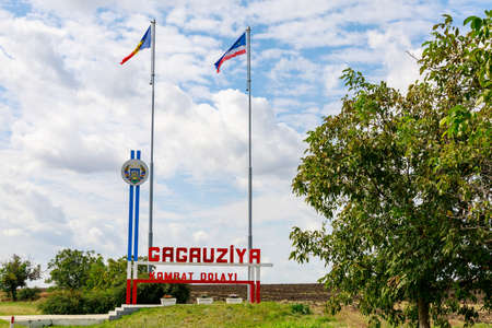The inscription in the Gagauz language GAGAUZIA KOMRAT DISTRICT. Welcome to Gagauzia, Moldova. Flags of Moldova and Gagauzia. Backgroundの写真素材