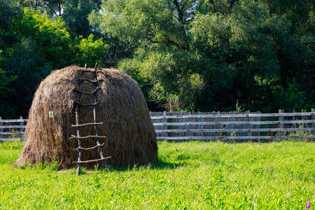 Classic typical village haystack with homemade wooden staircase. Selective focus. Rustic with copy space for text or letteringの写真素材