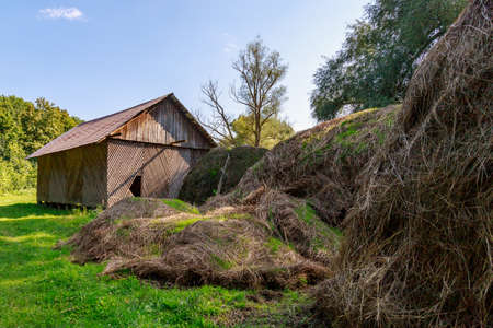 Rustic wooden hay storage building with an attic. Exterior of a barn in the village. Rustic background with copy space for text or letteringの写真素材
