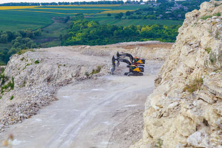 Excavators and heavy equipment in a natural stone and limestone quarry. Illustrative editorial. July 18, 2021 Brynzen Moldova.のeditorial素材