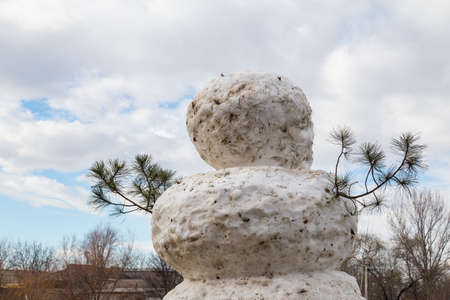 A huge spring snowman in a melted meadow. Background with copy space for lettering or textの写真素材
