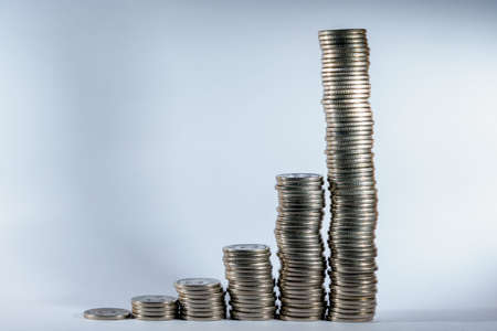 Stacks of coins in a growing progression. Background with copy space for text or inscriptions. Business economic development conceptの写真素材