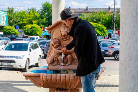 Tourists drink tap water in the park. Welcome to Gagauzia. Illustrative Editorial. September 5, 2021 Comrat or Komrat, Moldova.のeditorial素材