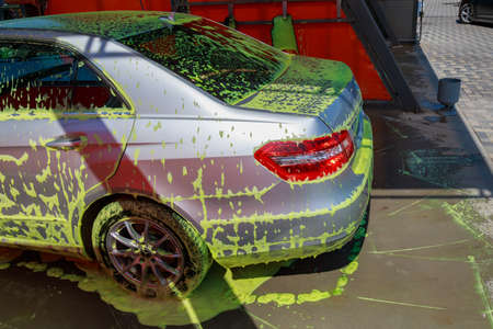 A car in foam at a modern city car wash. Background with copy space for text or lettering. Illustrative editorial. July 23, 2021, Balti Moldova.のeditorial素材