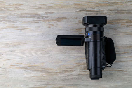 Handicam or a small handheld video camera is on the table. Tool operator or a journalist. Background...