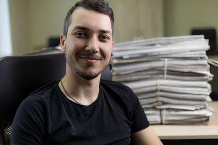 Young male journalist at the workplace. Selective focus, lifestyle portrait.の写真素材