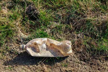 Bottles discarded in nature. Environmental pollution with plastic waste. Hazardous and toxic waste. Ecological disaster of the planet. Causes of climate change. Background with copy space for textの写真素材