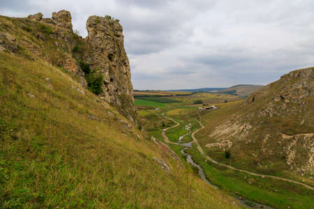 Wild rocky and mountainous nature of Eastern Europe. Landscape background with copy space for text. Selective focus, toned. Corjeuti village, welcome to Moldova.の写真素材