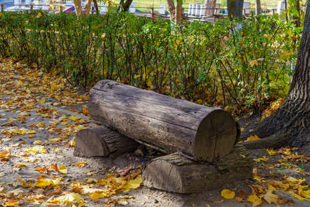 Park bench made of wooden beams. Rest in travel for a tourist. Natural autumn background with copy space for textの写真素材