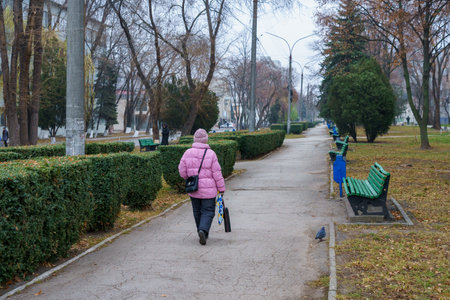 December 5, 2021 Balti, Moldova. Illustrative editorial. The back of a man walking along a boulevard with benches.のeditorial素材