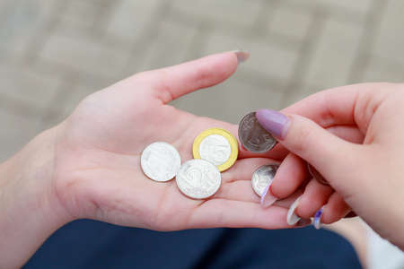 Female hands are counting coins. Background with copy space for text