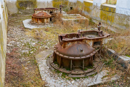 Old rusty metal mechanisms at an abandoned hydroelectric power plant. Apocalyptic background with copy space for text.の写真素材