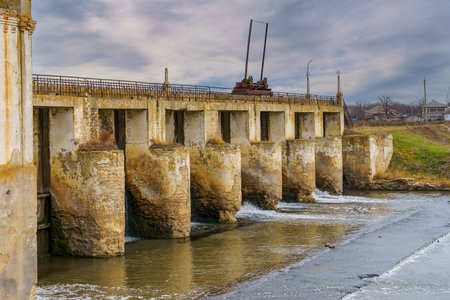 An old abandoned hydroelectric power station on a small river. Apocalyptic background with copy space for text.の写真素材