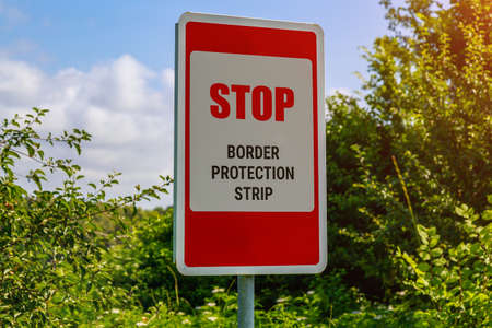 The inscription or text in English STOP BORDER PROTECTION STRIP. Warning post about the state border. Background with copy spaceの写真素材