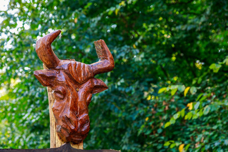 Abstract carved rustic decorative head of a bull or bison. Wood carving is a popular hobby in the culture of different peoples of the world.の写真素材