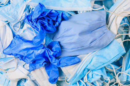 Used disposable medical masks and gloves background. Medical waste. Garbage and the environmental impact of the covid-19 coronavirus pandemic. Ecology concept.の写真素材
