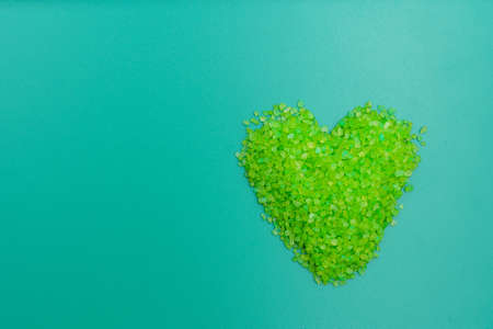 Aromatic sea salt for bath and relaxation poured in the shape of a heart. Background with selective focus and copy space for text or inscriptionの写真素材