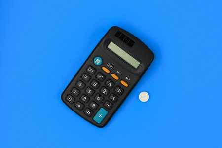 Classic medical white pill with risk mark and calculator. The concept of financial costs for the treatment of the disease. Background with copy space for text.の写真素材