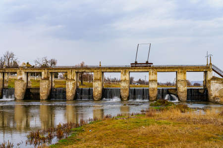 An old abandoned hydroelectric power station on a small river. Apocalyptic background with copy space for text.の写真素材