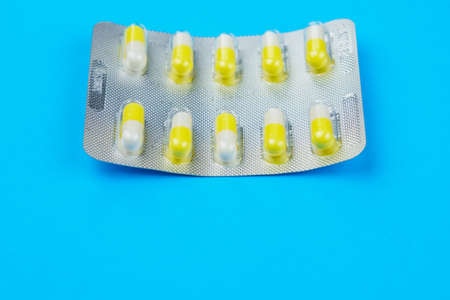 Blister or pack of ten medical tablets or pills. Classic traditional medical blue background. Selective focus and copy space.の写真素材