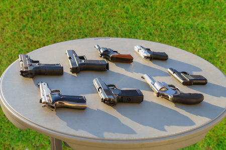 Pistols on the table among weapons, selective focus. Crime news background. The concept of rules for...