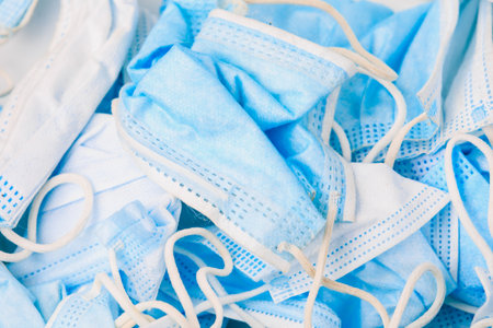 Used disposable medical masks background. Medical waste. Garbage and the environmental impact of the covid-19 coronavirus pandemic. Ecology concept.の写真素材