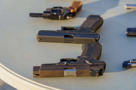 A gun on the table among the weapons, selective focus. Crime news background. The concept of rules...