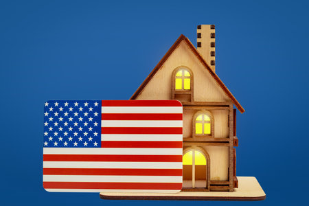 Wooden toy symbolic house and USA flag on a cold background.の写真素材