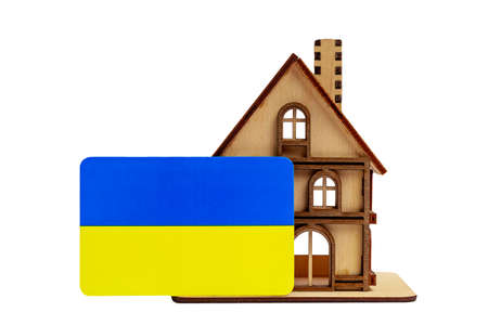 Wooden toy symbolic house and the flag of Ukraine on a white isolated background.の写真素材
