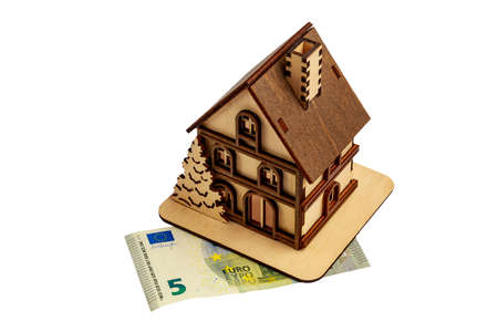 Wooden toy symbolic house on a euro bill, white isolated background.の写真素材