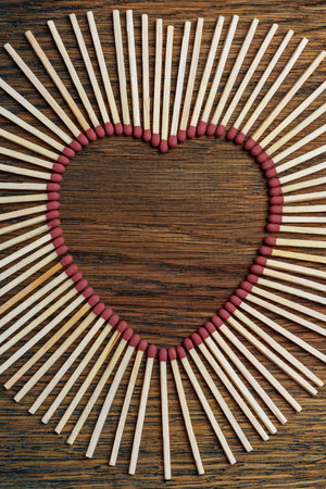 Matches on a wooden background form an abstract heart. Copy space for text. Passionate hot love concept. A metaphor for kindling loving feelings.の写真素材