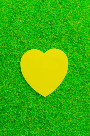 Paper sticker in the shape of a heart on the background of sea aromatic bath salts. The concept of romantic enjoyment. Abstract copy spaceの写真素材