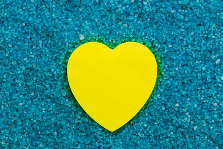 Paper sticker in the shape of a heart on the background of sea aromatic bath salts. The concept of...