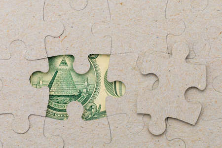 Missing puzzle piece and framed US dollars. Background with copy space for text